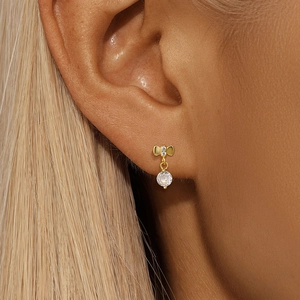 Close-up of S925 silver bow earrings with hanging round CZ diamond on a female model