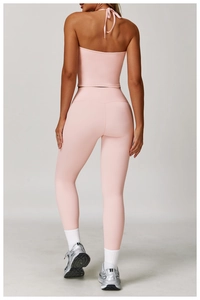 Rear view of pale pink halter neck yoga set showing back tie detail and high waist leggings