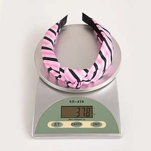 Serre-tête noué rayé rose et noir sur balance électronique pesant 37,8 grammes