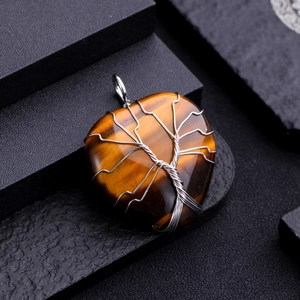 Macro shot of tiger eye stone heart pendant with silver wire wrap tree of life design