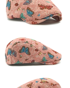 Detailopname van roze jacquardstof met geborduurde vlinders op de vintage baretpet