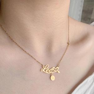 Close-up of gold Leo necklace with heart charm and zodiac pendant on neck