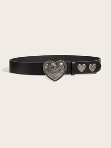 Close-up of black leather punk belt featuring vintage heart-embossed metal buckle