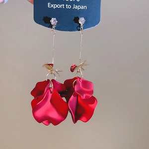 Detailed close-up of dark red petal tassel earrings with zircon studs and golden finish