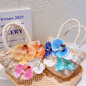 Handwoven bohemian beach bag with orchid flowers and elegant pearl chain handle