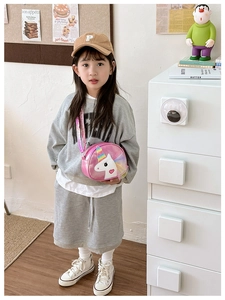 Pink unicorn crossbody bag for girls shown in a stylish lifestyle setting with a kid model
