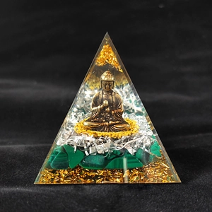 Macro detail of Orgone pyramid with copper Buddha statue and green malachite stones