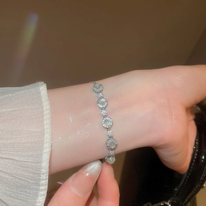 Détail d'un bracelet en opale et zircon avec motifs papillons sur le poignet d'une femme
