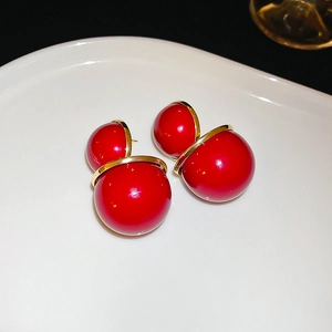 Gros plan d'élégantes boucles d'oreilles double sphère rouge avec anneaux dorés