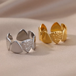 Detailed view of adjustable hammer texture rings in gold and silver on silk fabric
