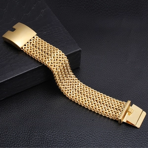 Detailed close-up of wide braided chain gold bracelet with a polished metal buckle