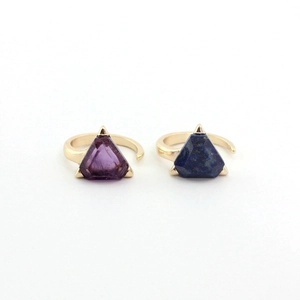 Adjustable gold rings with triangle amethyst and lapis lazuli stones on white background