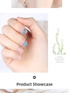 Macro detail of cat paw earrings with blue heart-shaped cubic zirconia in silver