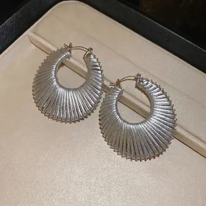 Boucles d'oreilles créoles évidées tissées argentées avec une texture géométrique