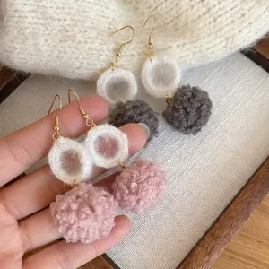 Eleganti orecchini in maglia con pompon grigi e rosa e ganci in metallo dorato per l'inverno