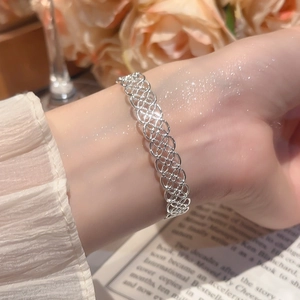 Vue détaillée du bracelet jonc argenté avec motifs floraux évidés et design métallique