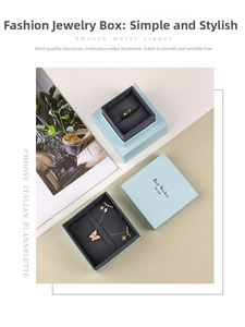 Detail view of light blue jewelry box with velvet lining, rings, and butterfly necklace