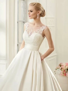 Detail of lace bodice and satin skirt ivory wedding dress with elegant side pockets
