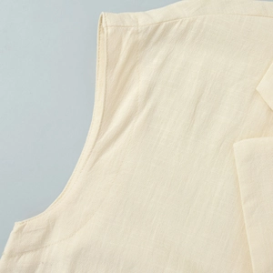 Close-up of beige cotton linen fabric showing stitching detail on sleeveless dress