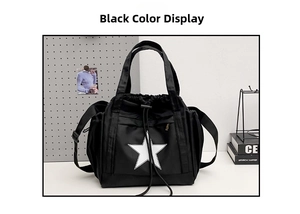 Detail of black nylon drawstring tote bag with a white star print and adjustable strap