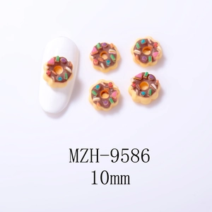 Detailed macro view of 10mm resin chocolate donut nail art charms with colorful sprinkles