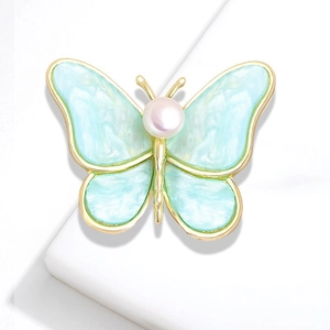 Detail of butterfly brooch with light blue pearlescent wings and central pearl decoration