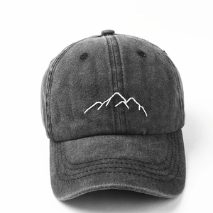 Detail view of white mountain embroidery on washed dark grey cotton baseball cap