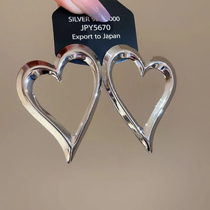 Detailed close-up of large heart-shaped S925 sterling silver earrings with mirror polish