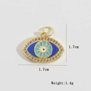 Detail view of gold evil eye pendant with blue zircon inlay measuring 1.7cm and 1.4g