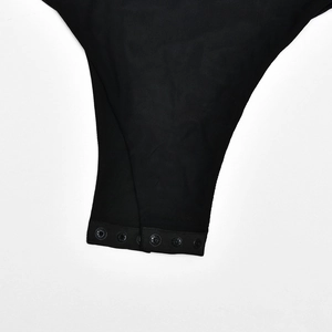 Detailed macro view of the crotch closure and snap buttons on a black sheer mesh bodysuit