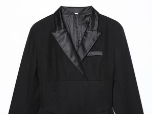 Détail d'une robe blazer noire avec revers en satin et coupe cintrée structurée