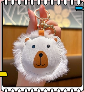 Close-up of a white and brown faux leather lion keychain with plush trim and gold hardware