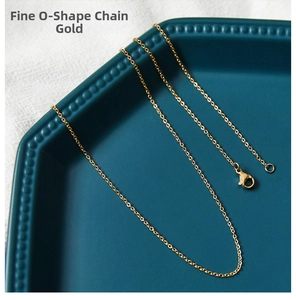 Close-up of golden stainless steel cable chain necklace with lobster clasp on blue plate