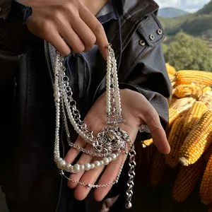 Multi-layer layered necklace featuring white pearls and a silver lion head pendant