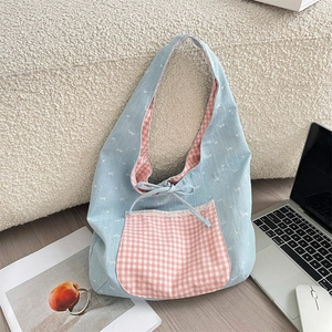 Detail view of the light blue bow print tote bag with pink checkered pocket and lace trim