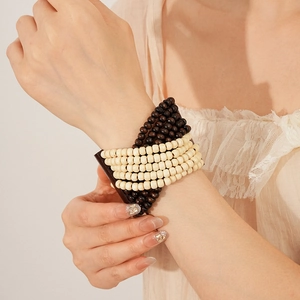 Detail of bohemian multilayered dark brown and cream wood bead stretch bracelet