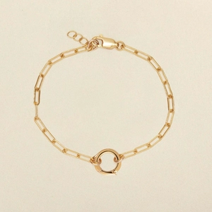 Golden paperclip chain bracelet with a round toggle clasp and minimalist charm design