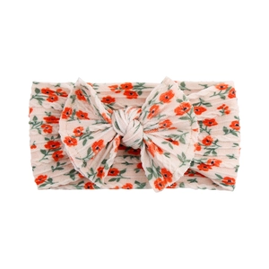 Detail of pink baby headband with red floral pattern and soft double-layered bow knot