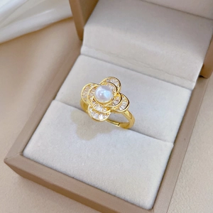 Detailed macro of a gold flower ring with pearl and cubic zirconia in a jewelry box