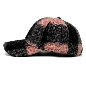 Close-up of thick bouclé teddy fleece material on pink and grey plaid baseball cap