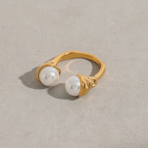 Detailed close-up of a gold-plated titanium steel open ring featuring dual white pearls