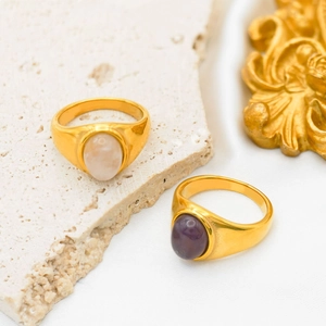 Macro shot of vintage 18k gold plated wide rings with purple and cream gemstones