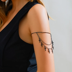 Detail of gothic black multi-layer arm chain with metallic cross pendants on a model