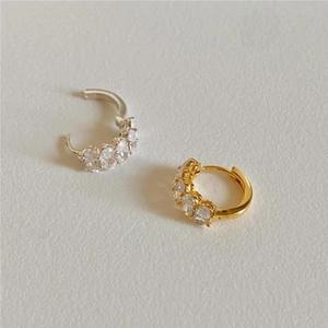 Detail of silver and gold hoop earrings with oval-cut cubic zirconia inlays