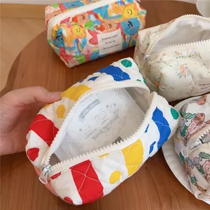 Detailed close-up of quilted floral and bear pattern makeup bags with zipper closure