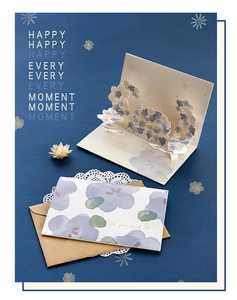Detail of 3D pop-up floral card with kraft envelope and patterned insert on blue background