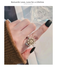 Close-up of rotatable ship wheel ring with crystal accents on a woman's index finger