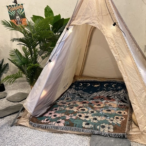Detail of woven camping blanket with Van Gogh star and sunflower pattern inside a canvas tent