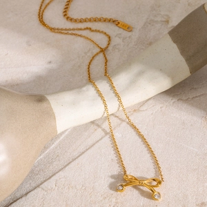 Detailed close-up of 18k gold butterfly pendant with sparkling zircon stone
