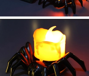 Close-up of black spider LED candle light with warm orange glow for Halloween decor